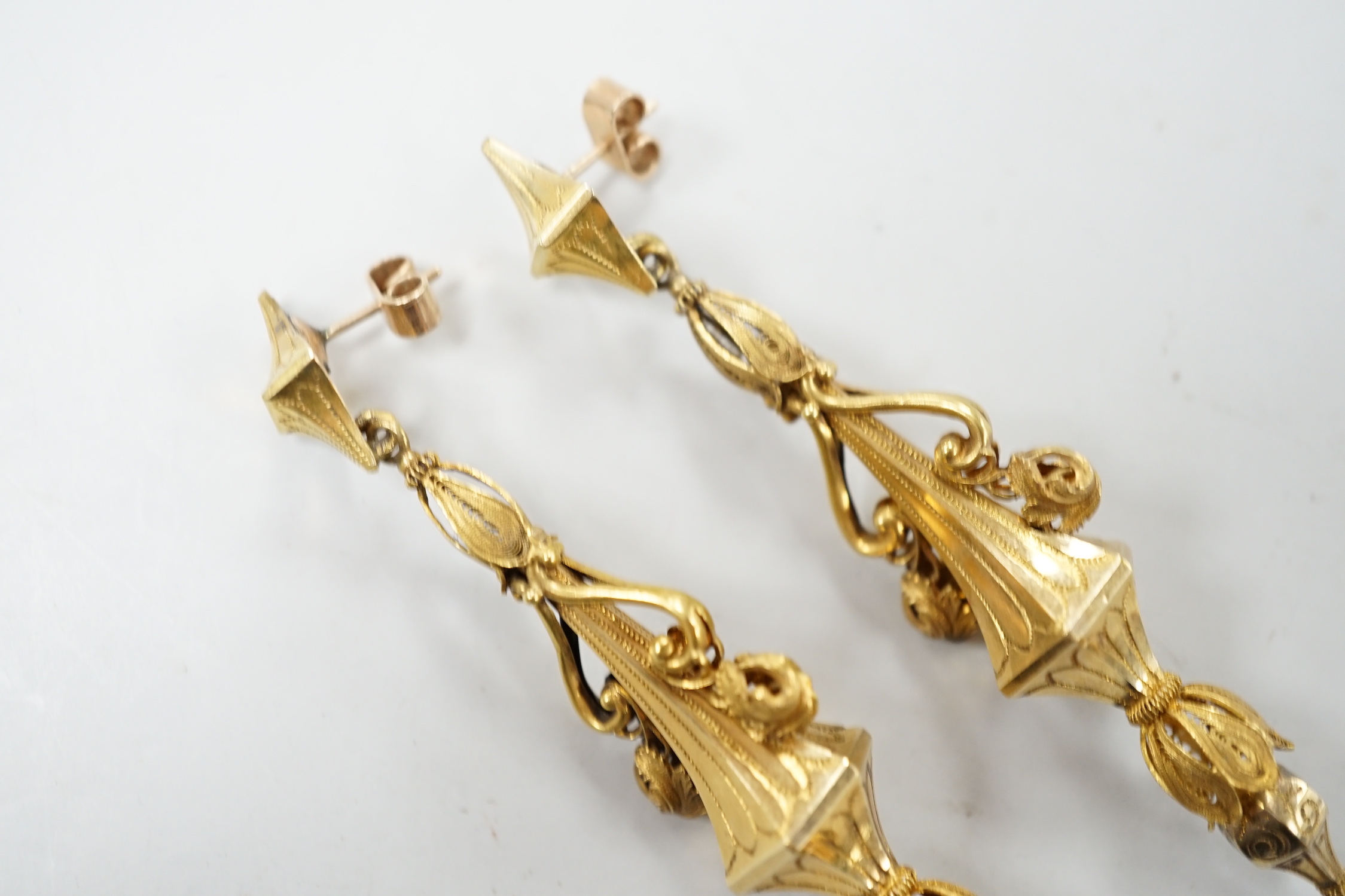 A pair of early 20th century yellow metal drop earrings, with scroll decoration, (later fittings?), 81mm, gross weight 10 grams.
